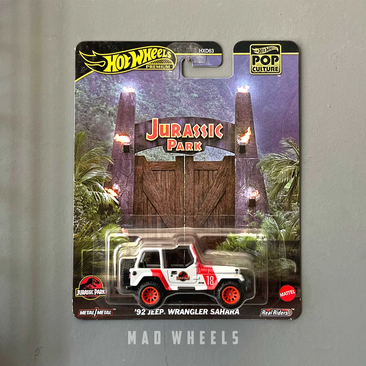 hot-wheels-premium-jeep-wrangler-jurassic-park-1-64-madwheels-1 ماکت ماشین فلزی جیپ رنگلر (Jeep Wrangler) هات ویلز پرمیوم سری Jurassic Park نسخه '92 Sahara | مقیاس ۱:۶۴ - Image 1
